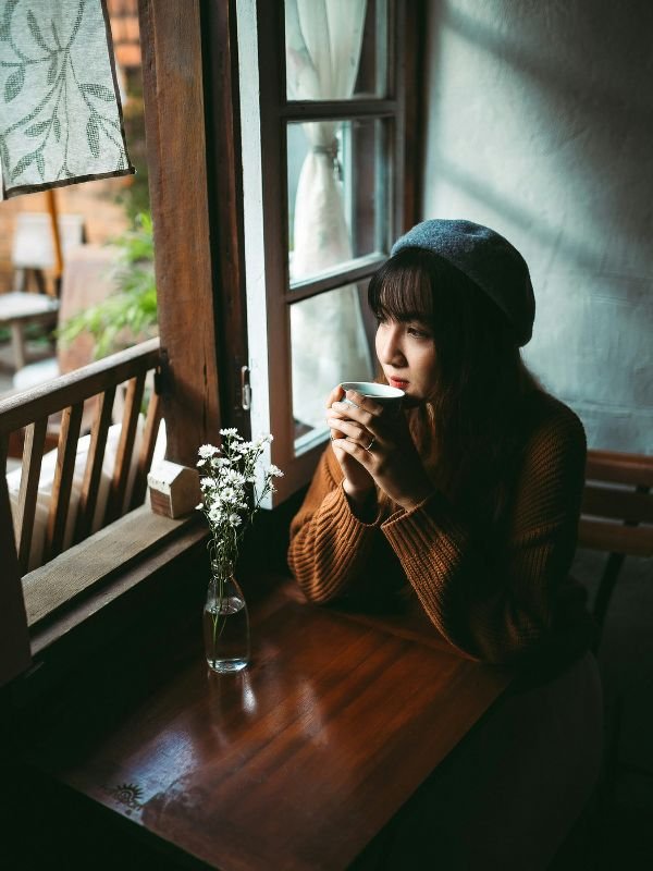 Woman relaxing in cafe morning after arrival during solo trip