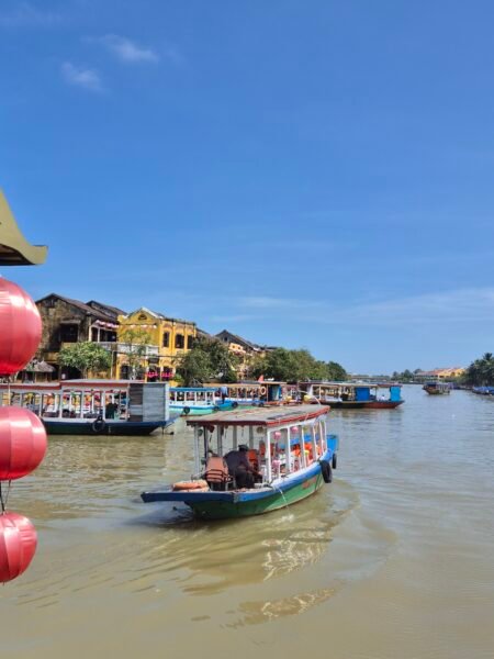 River scene in Hoi An with traditional boats and historic buildings