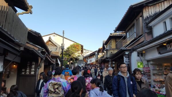 High pedestrian traffic along a narrow street in Kyoto