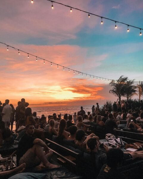 Crowd at a beach club during sunset in Bali showing busy social atmosphere