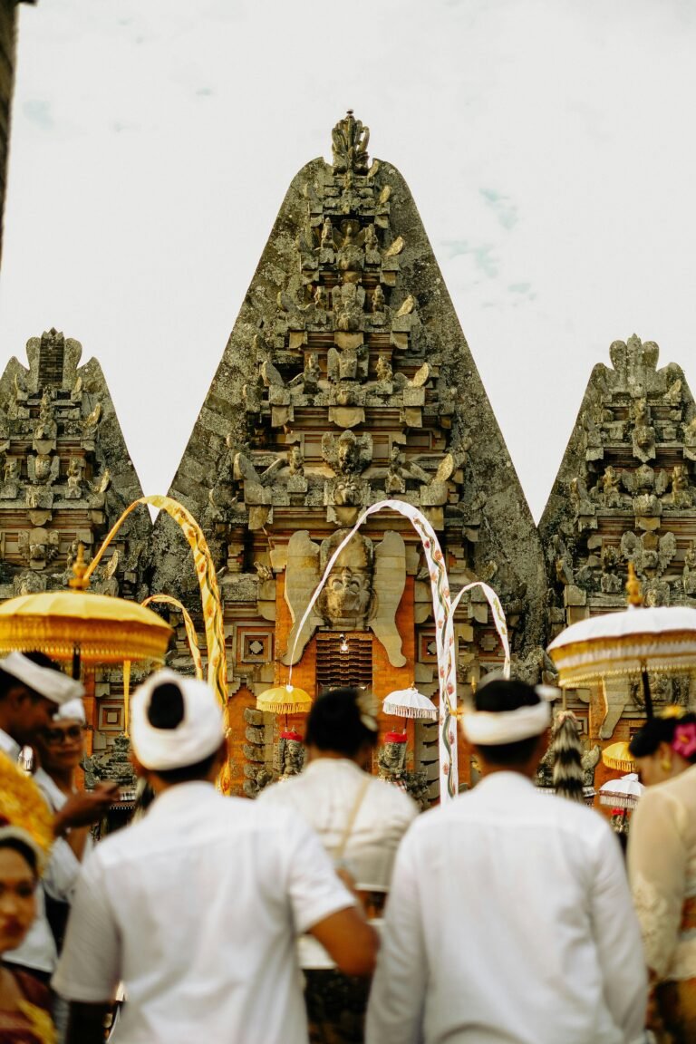 Balinese temple entrance with people in traditional dress during a ceremony in Bali Indonesia