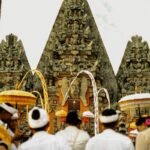 Balinese temple entrance with people in traditional dress during a ceremony in Bali Indonesia