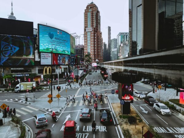 Busy Bukit Bintang intersection in Kuala Lumpur with pedestrians, traffic, and elevated monorail track
