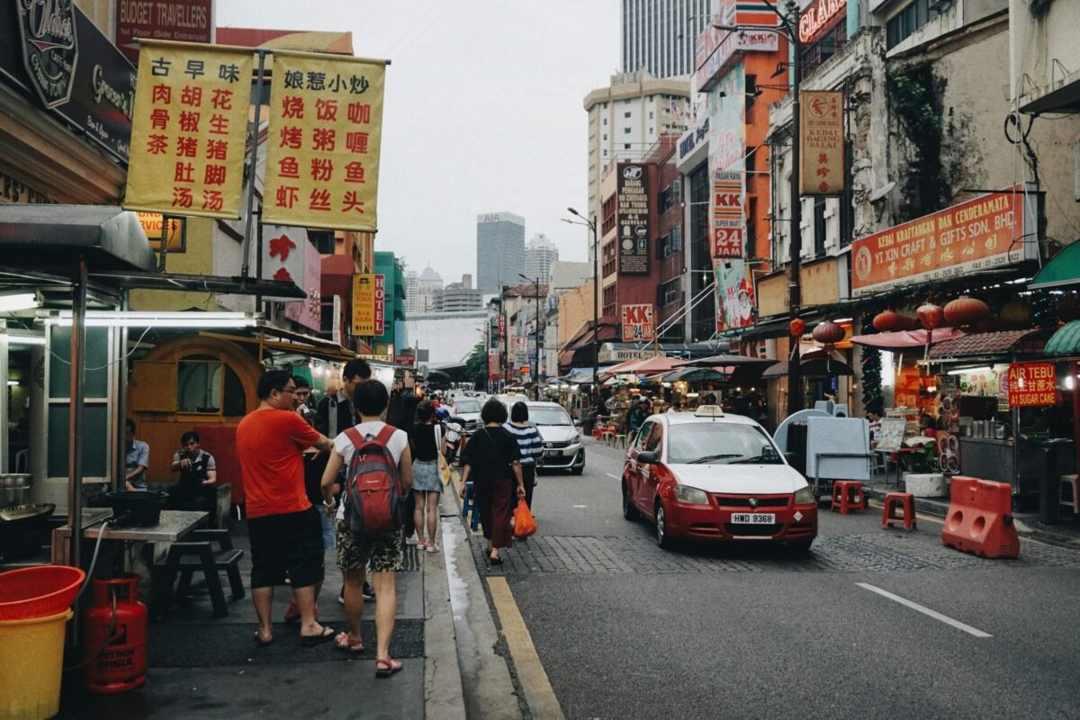 kuala-lumpur-petaling-street-chinatown Petaling Street in Kuala Lumpur Chinatown with street food stalls, traffic, and busy sidewalks