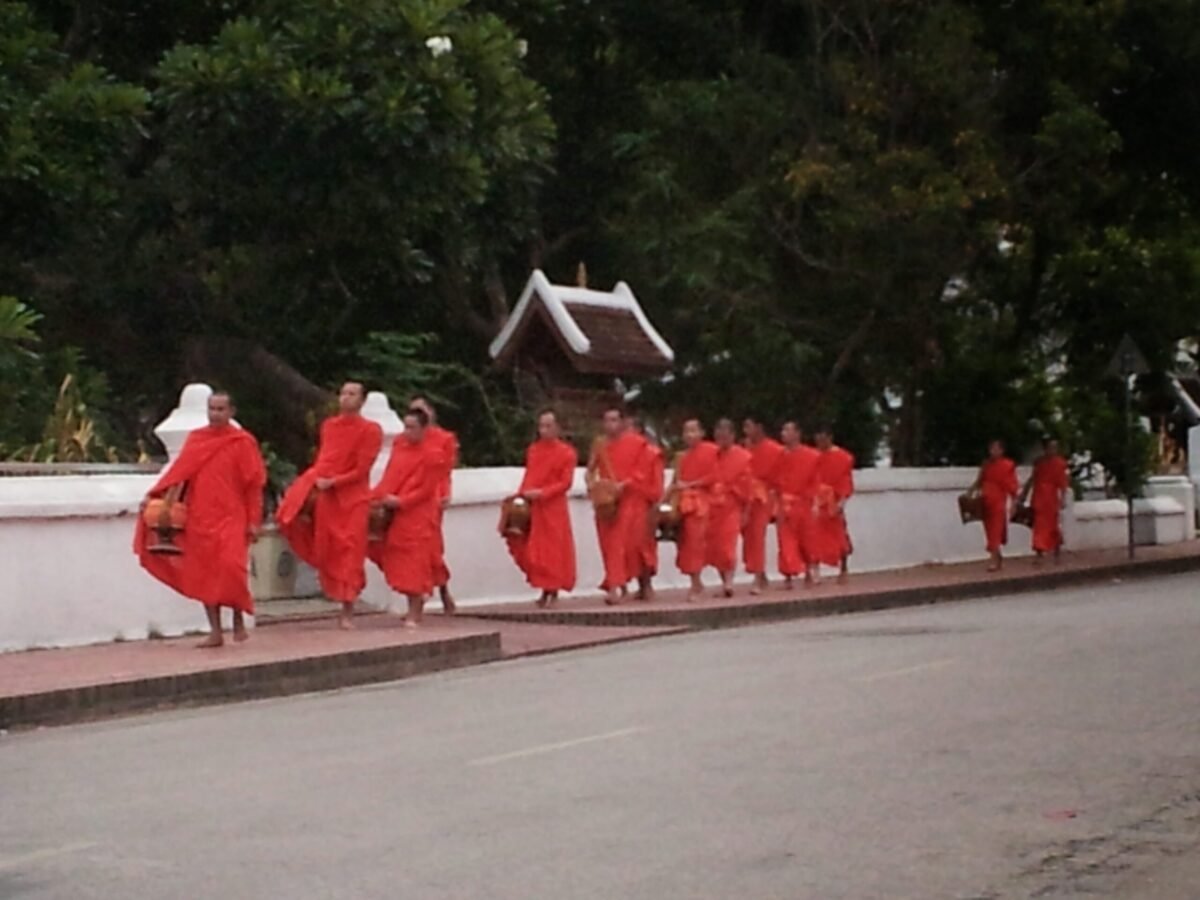 Monks walking along a quiet street in Luang Prabang during the morning alms ceremony