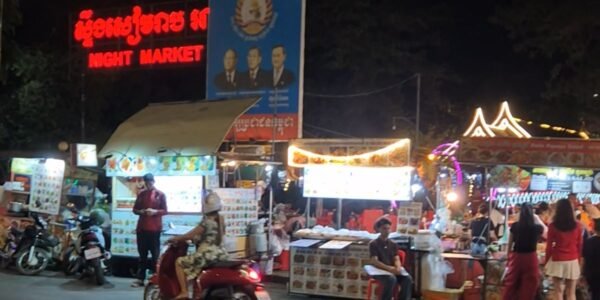 Siem Reap night market street food stalls at night with illuminated sign and evening street activity