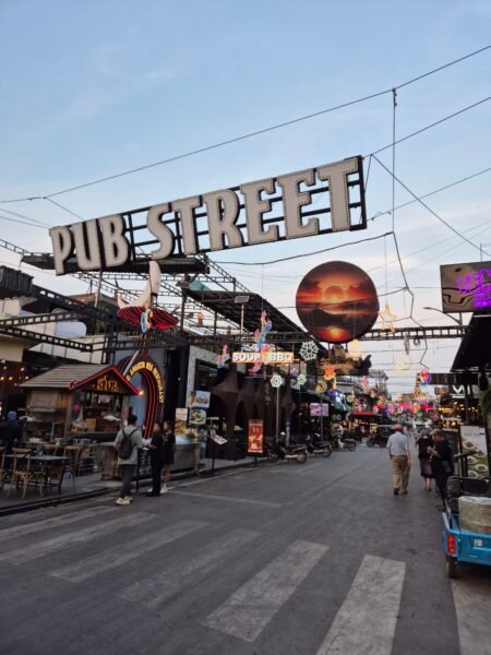 Pub Street in Siem Reap at dusk with restaurants, neon lights, and evening street activity