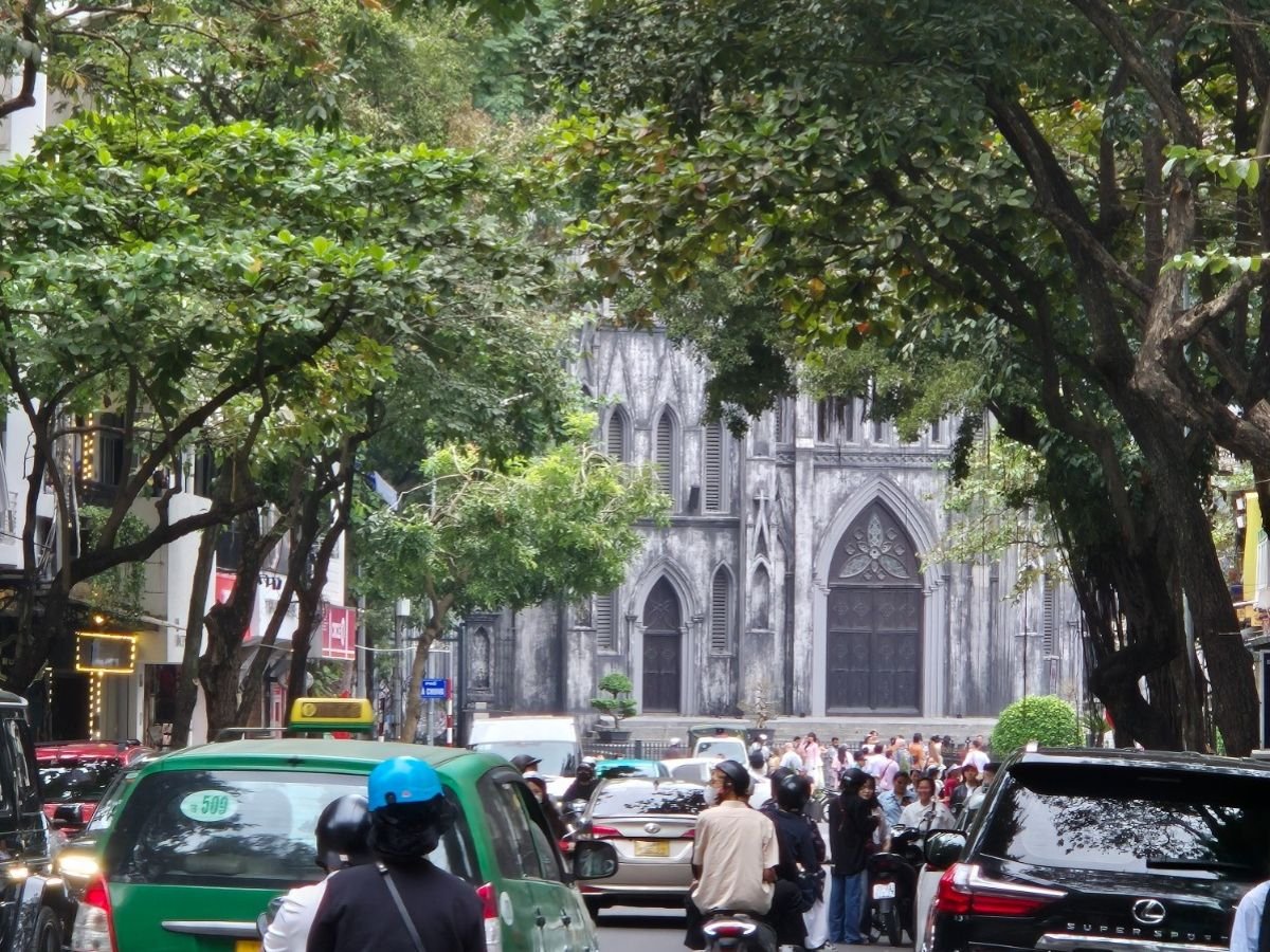 Street scene with traffic and motorbikes in front of St Joseph’s Cathedral in Hanoi, Vietnam