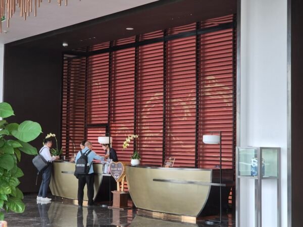 Hotel reception desk with clear check-in area, staff and guests in a structured, well-lit lobby environment