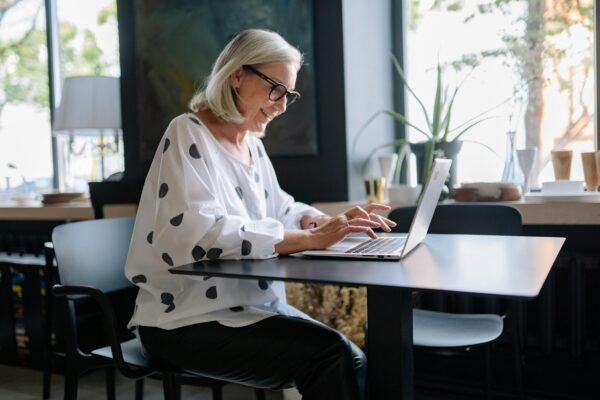 solo-dining-travel-working-laptop-cafe Mature woman dining alone while working on a laptop in a quiet café