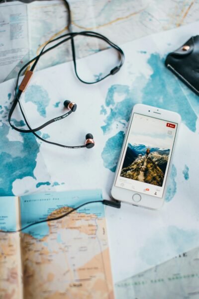 Phone and earphones on a world map while planning a solo trip