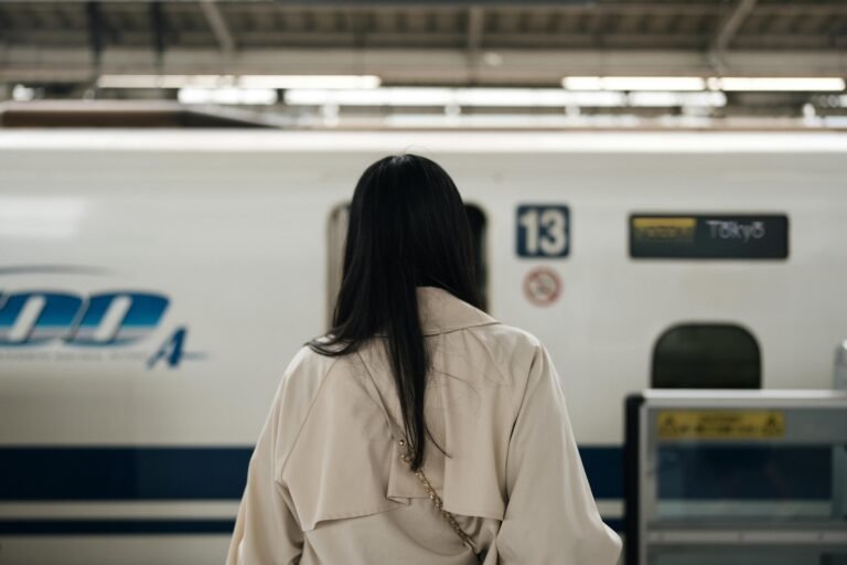 Traveler standing on a train platform for a day trip without luggage, illustrating movement without changing accommodation