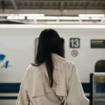 Traveler standing on a train platform for a day trip without luggage, illustrating movement without changing accommodation