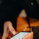 Close-up of a hand holding a smartphone with a map app open, navigating in low light.