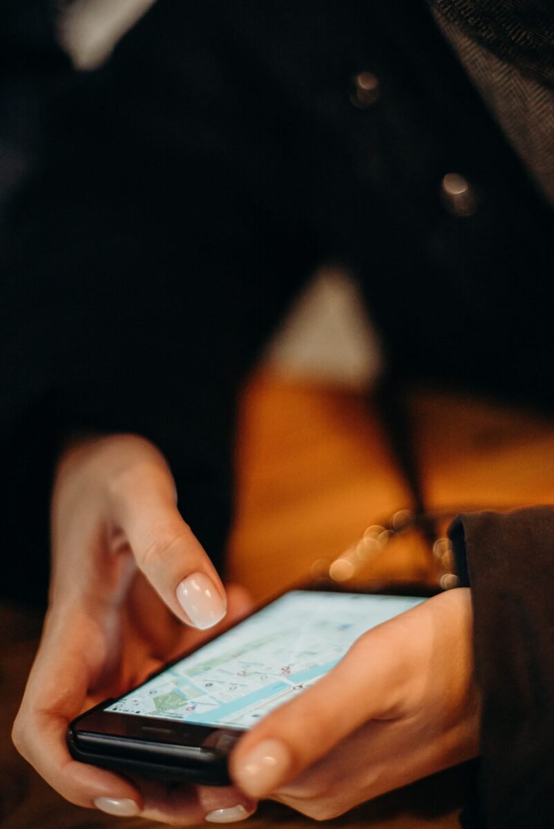 Close-up of a hand holding a smartphone with a map app open, navigating in low light.
