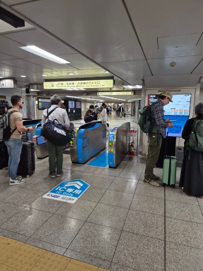 Travellers with luggage at Nagoya Station's JR and Meitetsu transfer gates, the tight connection point on a Tokyo to Takayama route