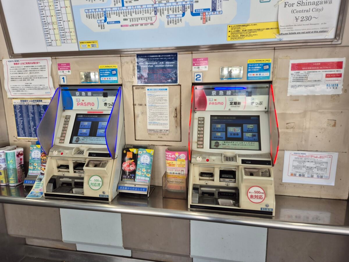 Two PASMO ticket machines at a Keikyu Line station in Japan, with English signage