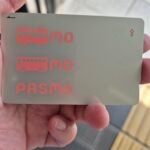 Close-up of a Pasmo transit card held in hand, showing the train and bus icons used across Japan