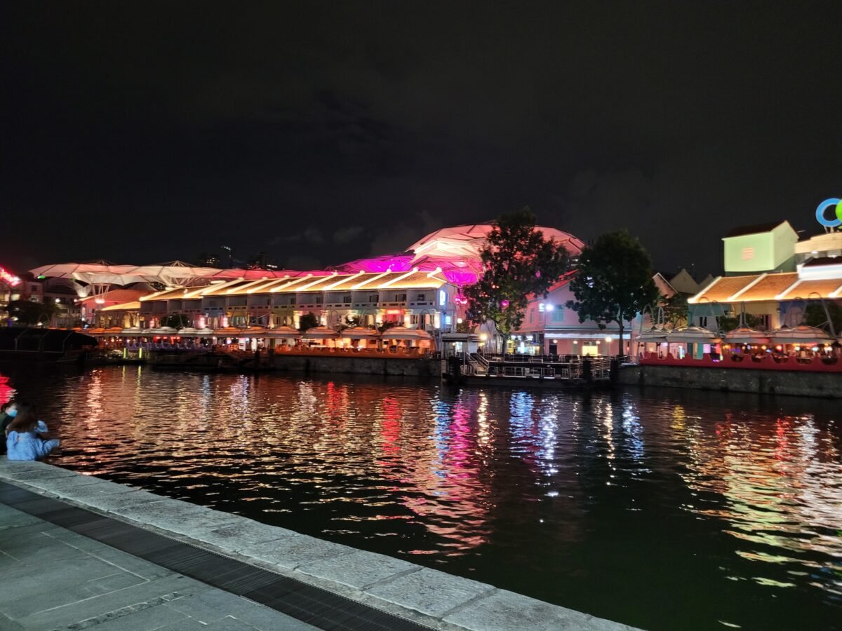 clarke-quay-singapore-river-night Clarke Quay's restored shophouses along the Singapore River lit up at night, with the canopy structures and riverfront restaurants reflected in the water
