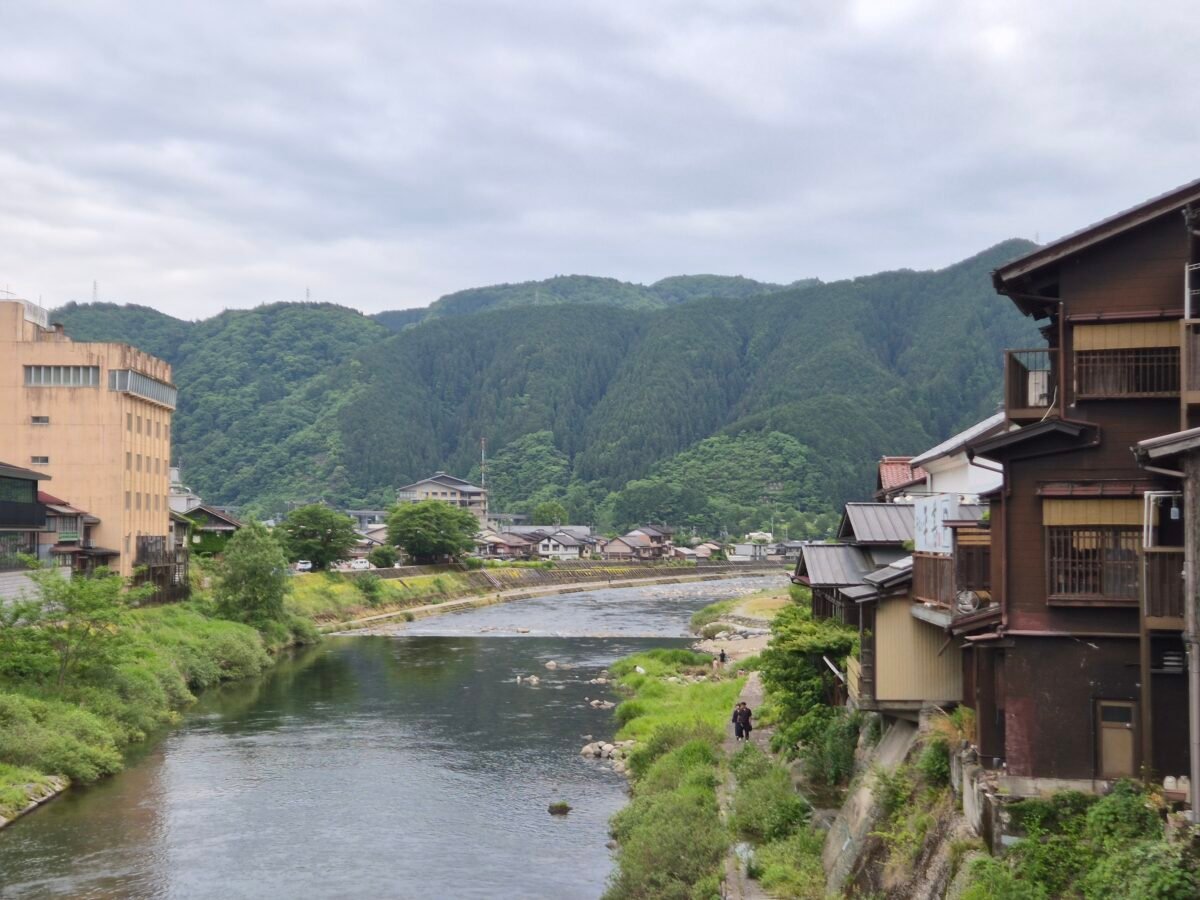 gujo-hachiman-river-mountains The river at Gujo Hachiman running between forested mountains, with wooden houses along the bank