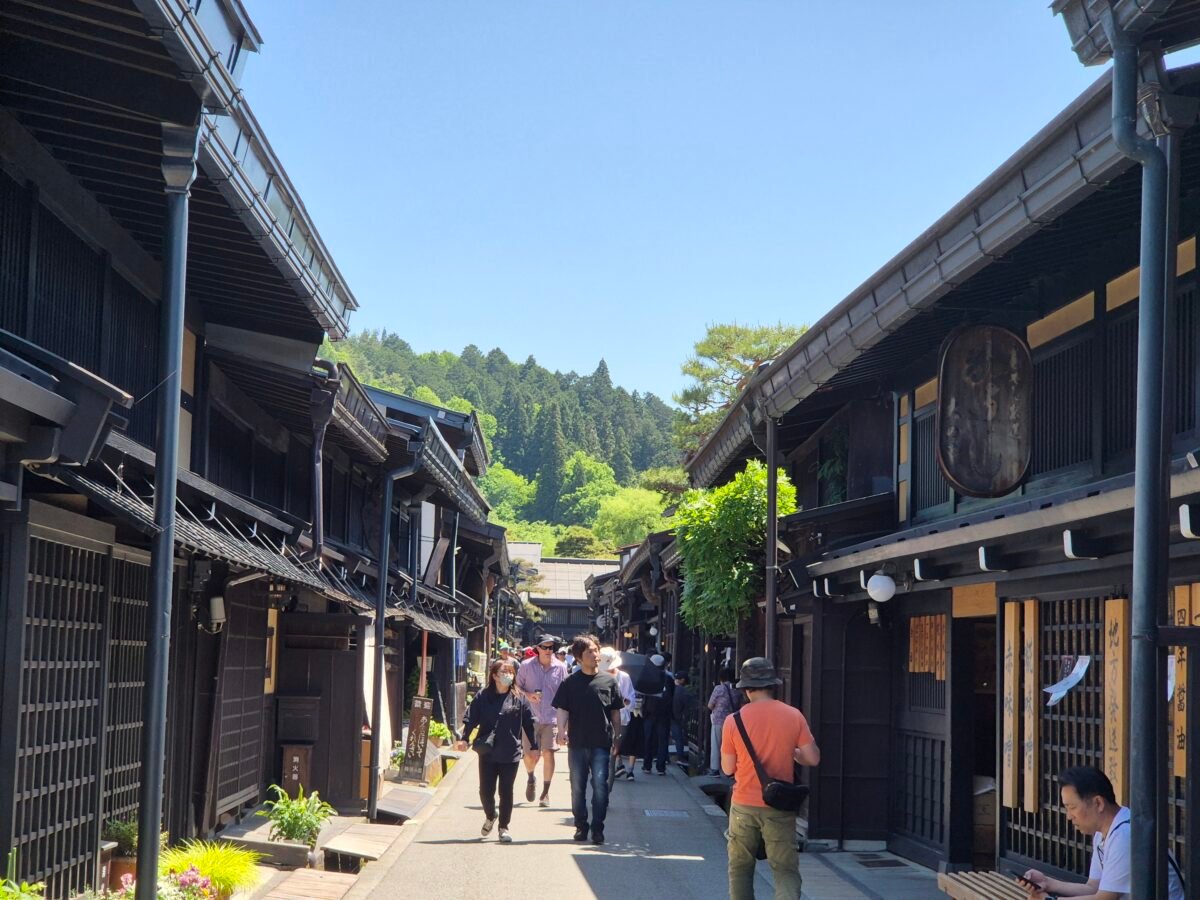 sanmachi-suji-old-town-takayama-japan Visitors walking along Sanmachi Suji, Takayama's preserved old town lined with traditional wooden merchant houses in Gifu Prefecture, Japan.