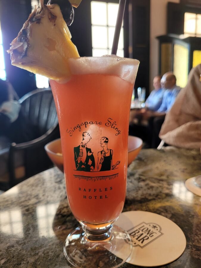 singapore-sling-long-bar-raffles-hotel Original Singapore Sling cocktail served in the Long Bar at Raffles Hotel, Singapore, in the branded glass with a pineapple garnish